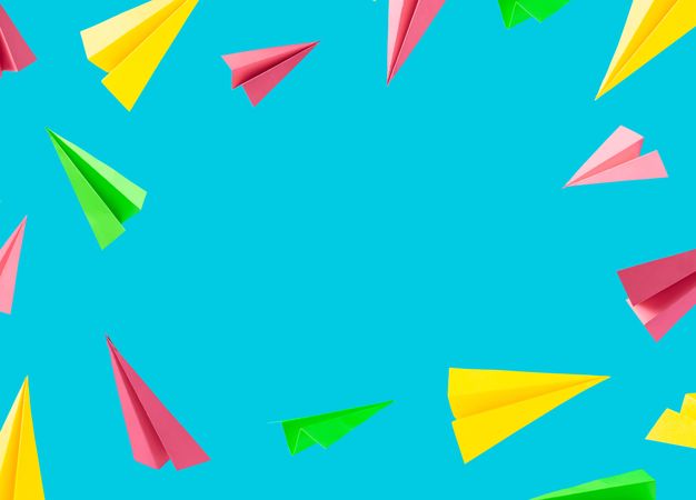 Colorful background pattern made with paper airplanes on sky blue background