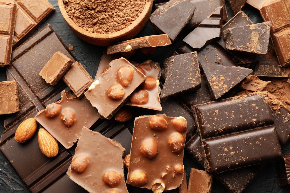 Chocolate, melted chocolate and almond on dark background