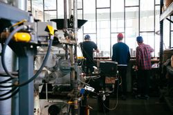 Back view of men tasting coffee at roasting facility