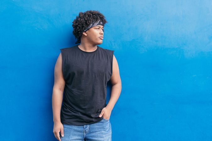 Young male standing against wall in city street