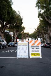 “Slow Down” sign in urban street with icons for pedestrians
