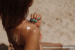 Sunscreen cream on tanned woman's back bx6vy5