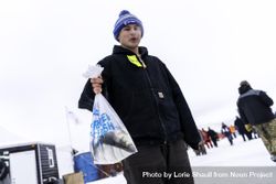 Nisswa, MN, USA - January 25th, 2020: A man holding a bag with a freshly caught fish 5pkM80