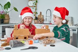 Content children applying icing on gingerbread houses