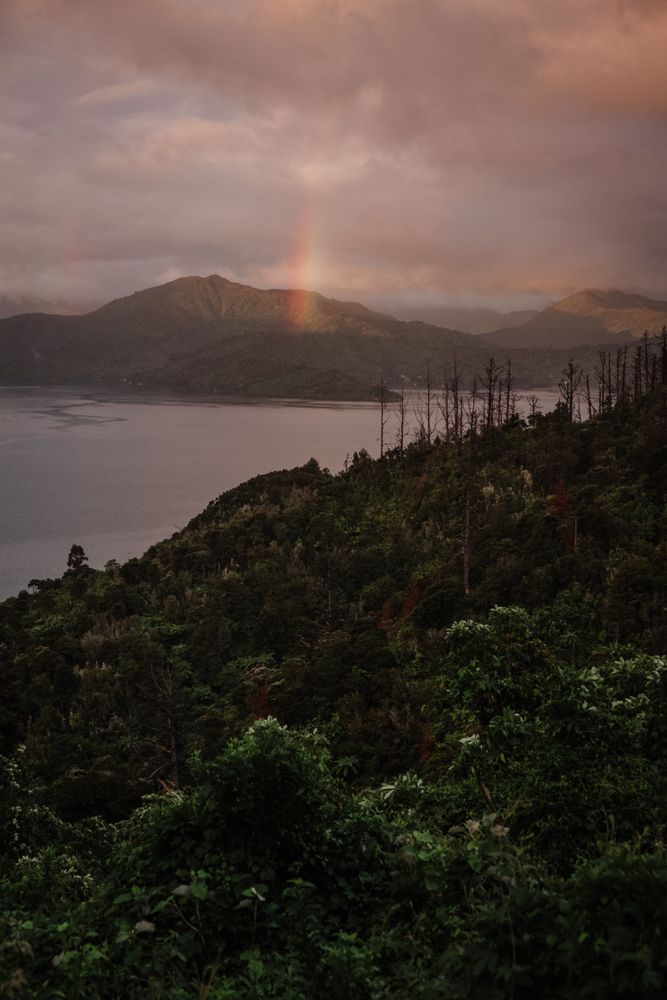 Rainbow over mountains on bay shore