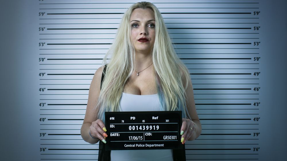 In Police Station Arrested Woman Posing for Front-View Mugshot.