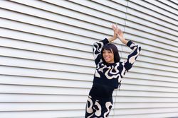 Happy dancer raising hands posing on the street