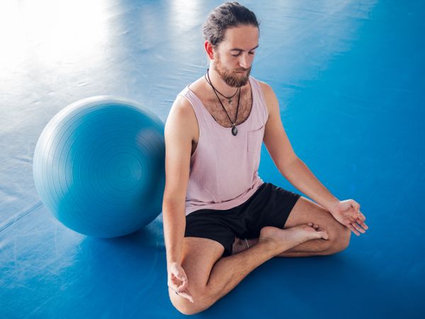 Male meditating in spacious room