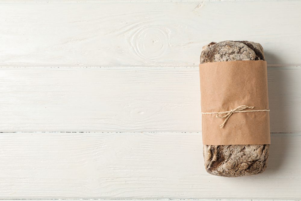Rye bread on wooden background, space for text and top view