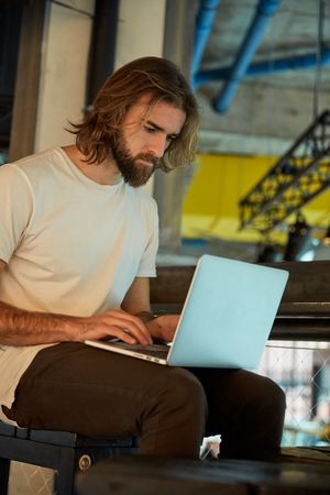 man seriously typing on laptop
