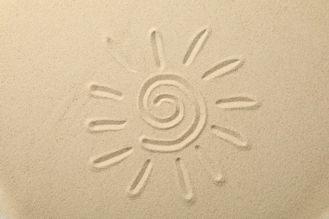 Suns drawing on dry sea sand, top view