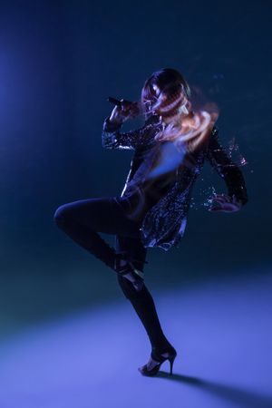 Stylish woman singing on stage