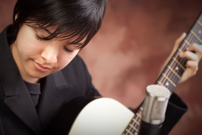 Woman with Closed Eyes Plays Guitar
