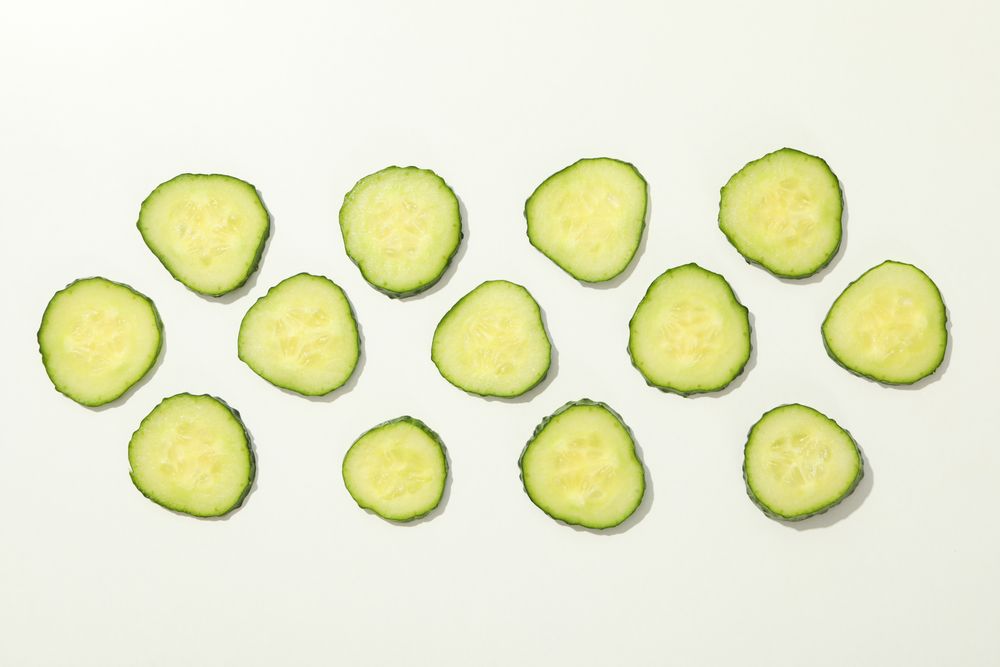 Cucumber slices on blank background, top view