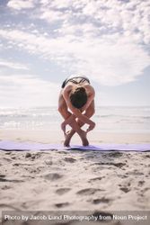 Fit woman doing yoga exercise at the beach on a sunny day bem6Kb