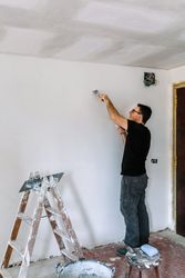 Bricklayer repairing the wall with a spatula