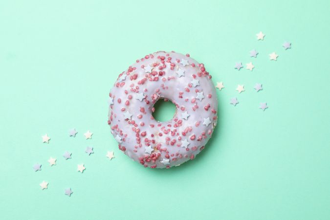 Tasty donut on mint background, top view