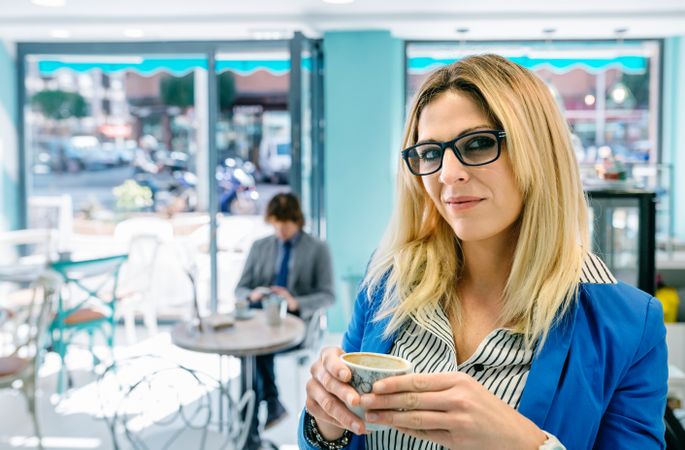 Woman posing holding a coffee