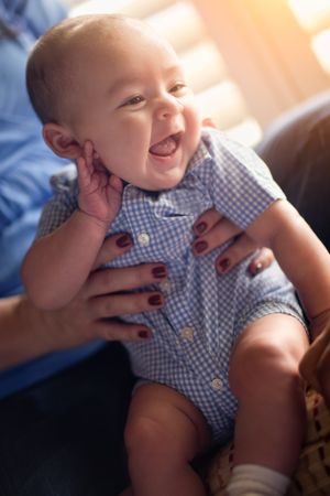 Happy Couple Enjoying Their Newborn Son In The Light of The Window.