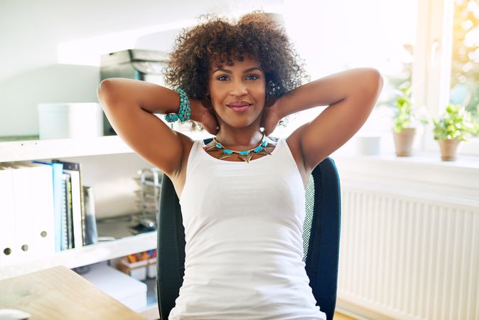 Black woman leaning back in her home office