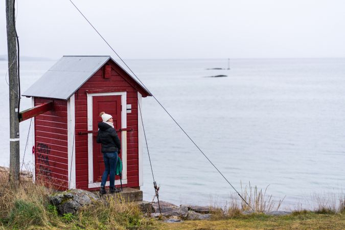 Female standing near cabin at coast