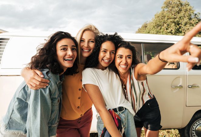 Group of young laughing women stopped during a road trip