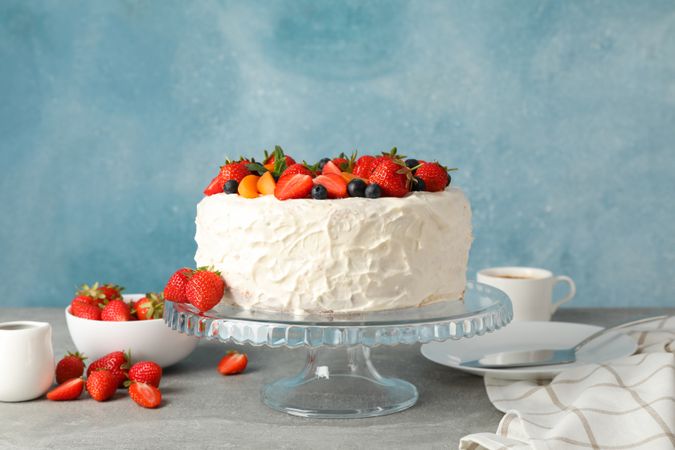 Composition with delicious berry cream cake on gray table. Tasty dessert