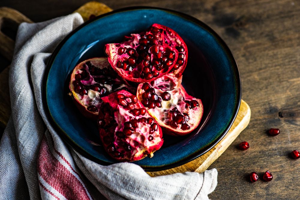 Open pomegranate on blue plate
