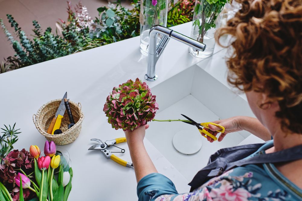 Woman making bouquet of hydrangeas in flower shop