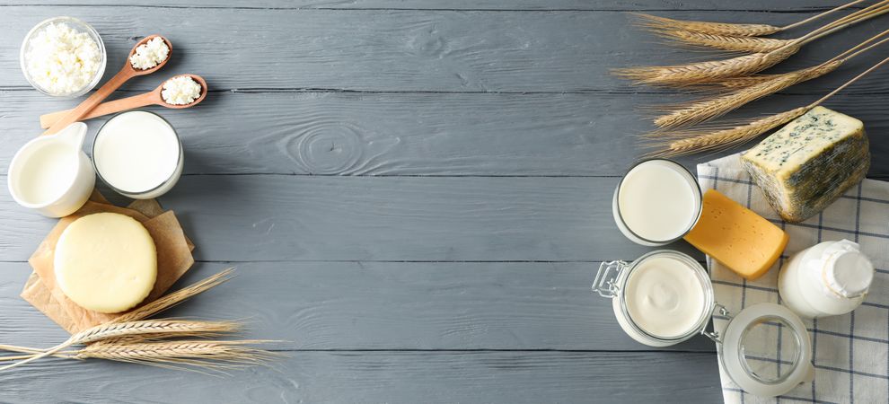 Flat lay. Different dairy products on grey wooden background, copy space