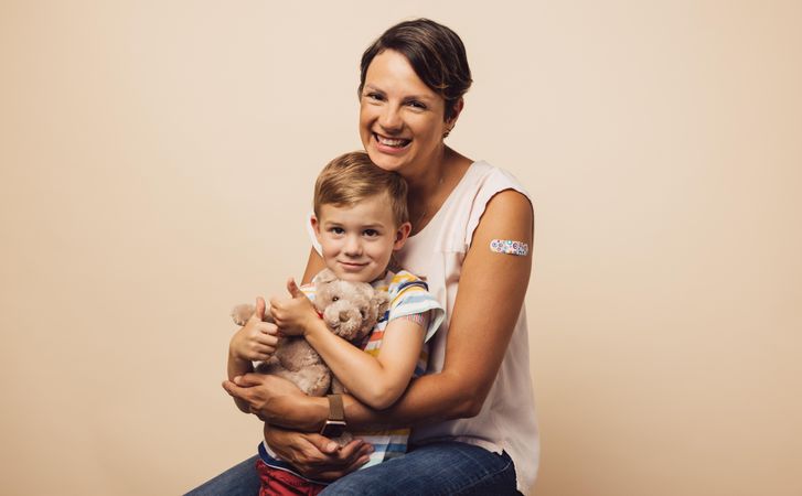 Mother and son with bandage on arm after getting immunity vaccine