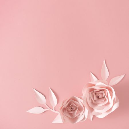 Paper rose flower, leaves and petals on pink background
