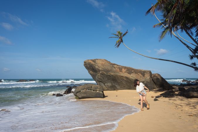 Woman in beachwear walking on sand