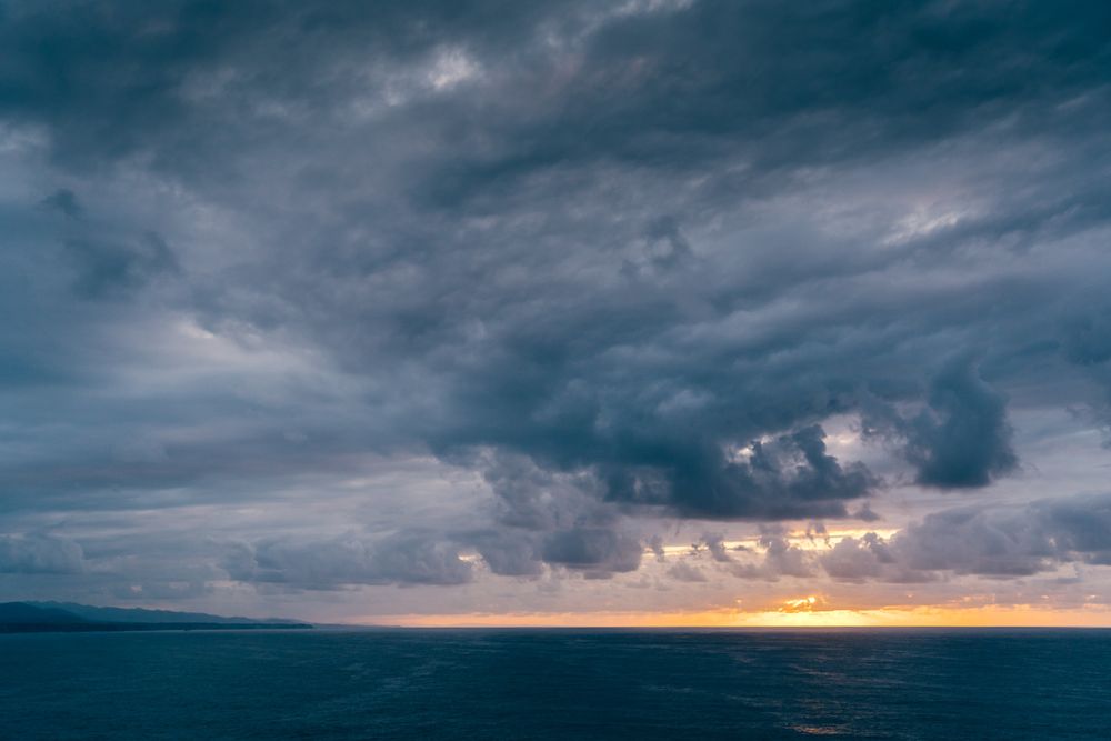 Gray clouds on sundown sky over sea