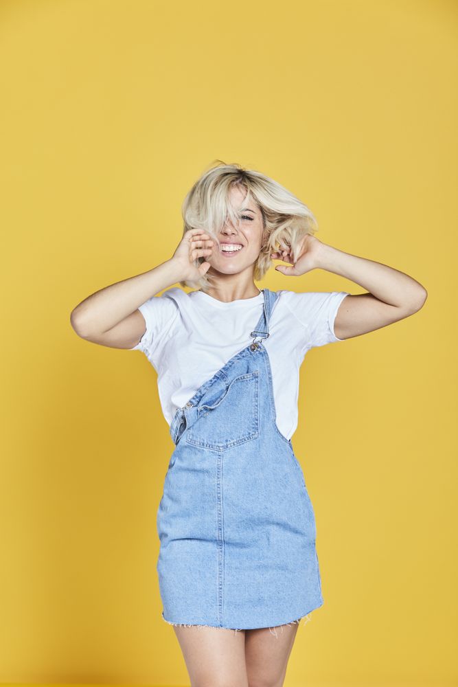 Trendy blonde female in denim sundress