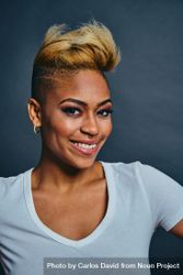Smiling Black woman with short blonde hair in gray studio 4drlD0