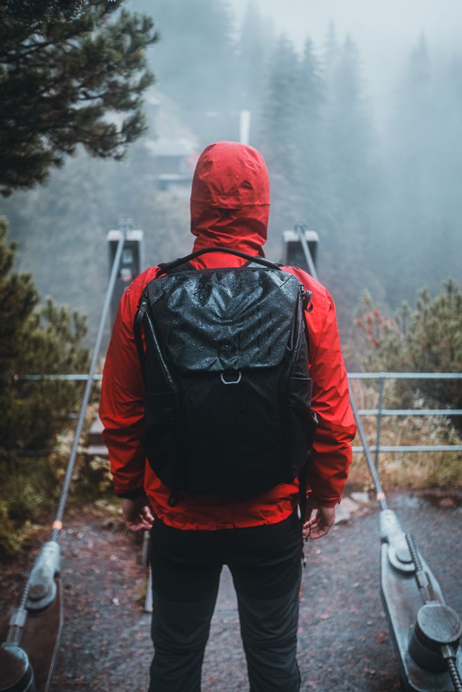 Man in red jacket and backpack standing outdoor