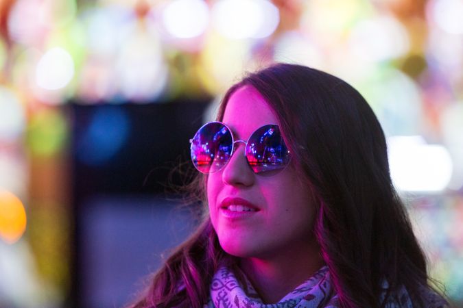 Stylish young woman near illumination on street