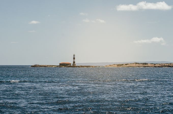 Lighthouse tower in a small rocky island