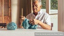 Man knitting warm clothes with wool yarn on table 4j7V8b