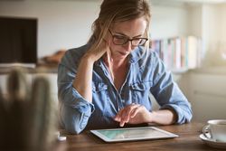 Woman reading a tablet on table