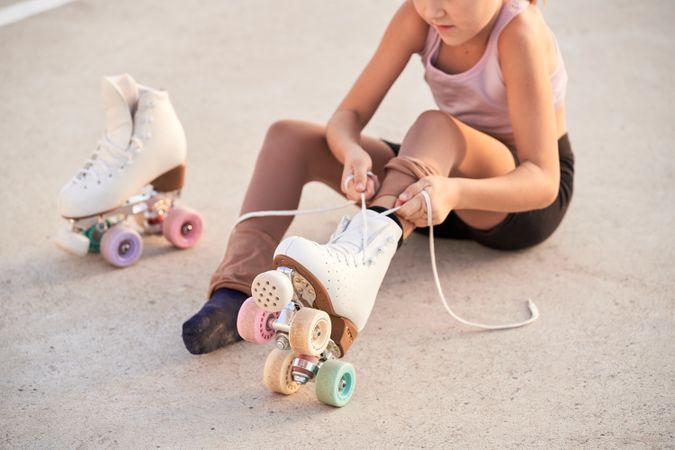 Unrecognizable girl putting on roller skaters