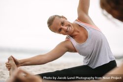 Smiling woman holding her foot while stretching at yoga class 49gBn0
