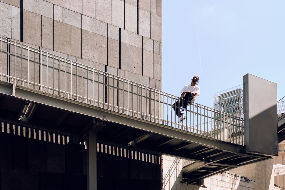 Black male sitting on bridge