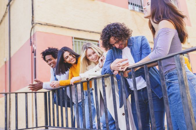 Portrait of happy male and female friends talking on street outside