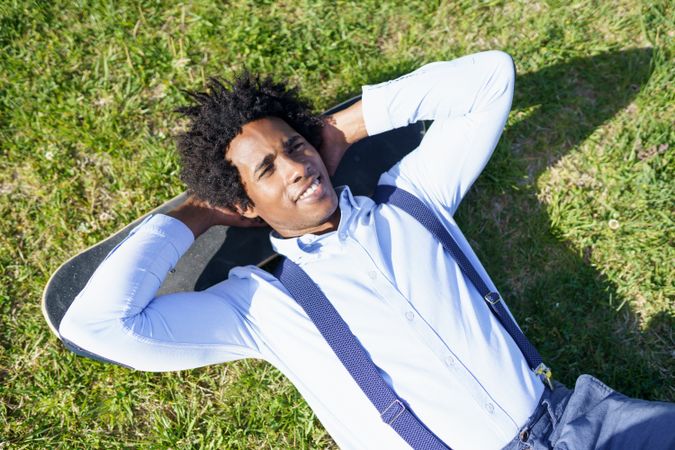 Content man lying back on his skateboard looking at the sky