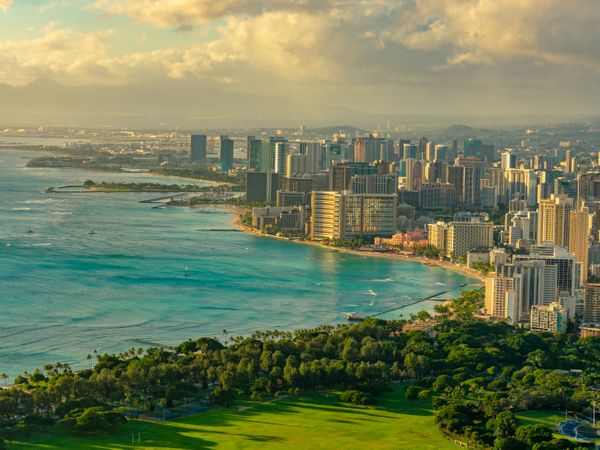 Cityscape of Honolulu by shoreline at sunset in Hawaii