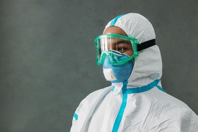 Side view of Black female medical worker in PPE gear and hazmat suit