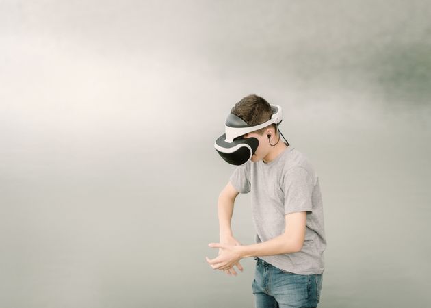 Young teenager with virtual reality glasses outdoors