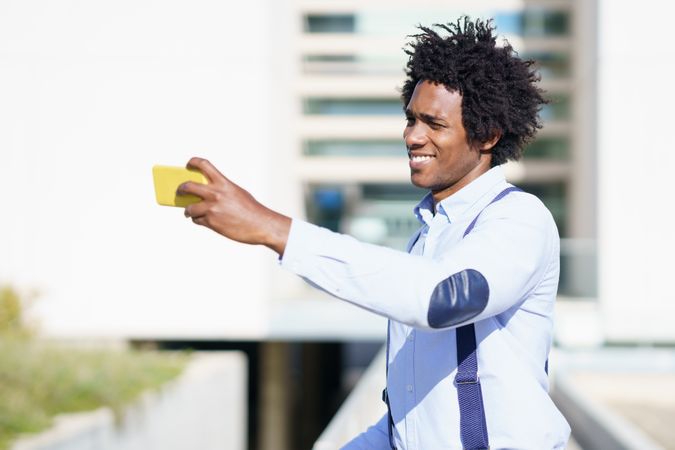 Man taking a photo with his phone on a sunny day